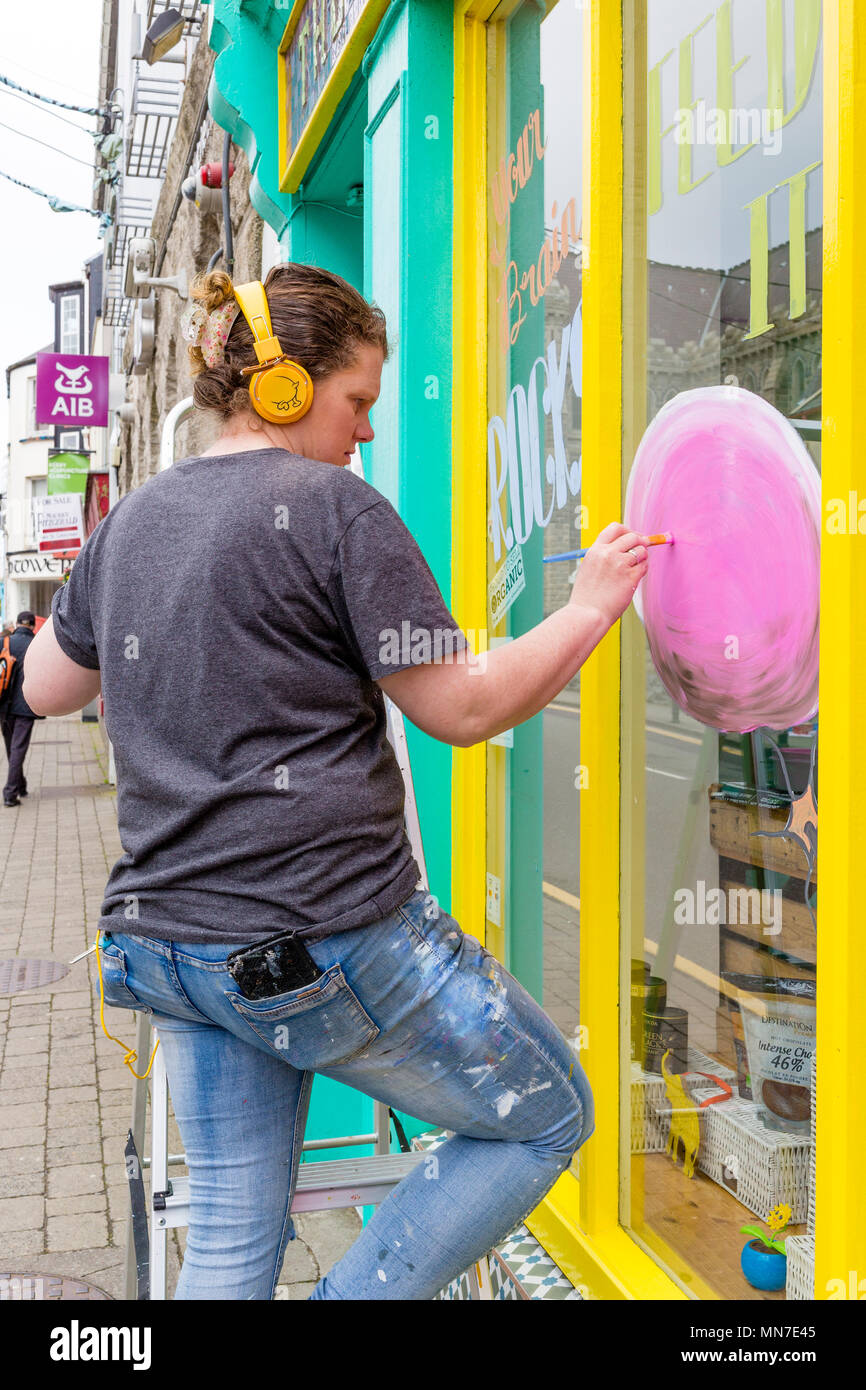 Femmina scrittore segno dipinto una vetrina, Cahersiveen, nella contea di Kerry Irlanda Foto Stock