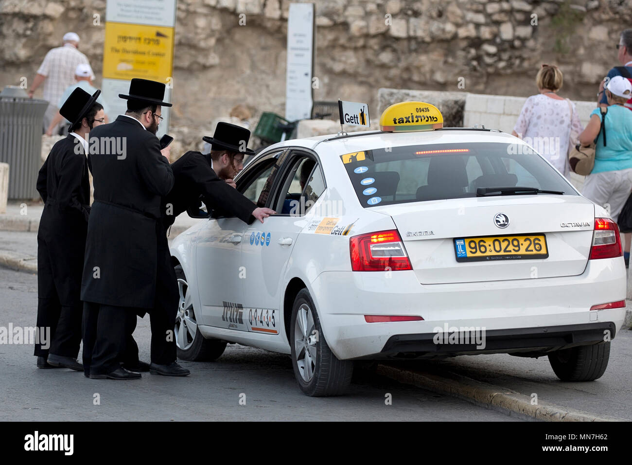 Gli ebrei ortodossi ordinare un taxi sulla strada di Gerusalemme Foto Stock