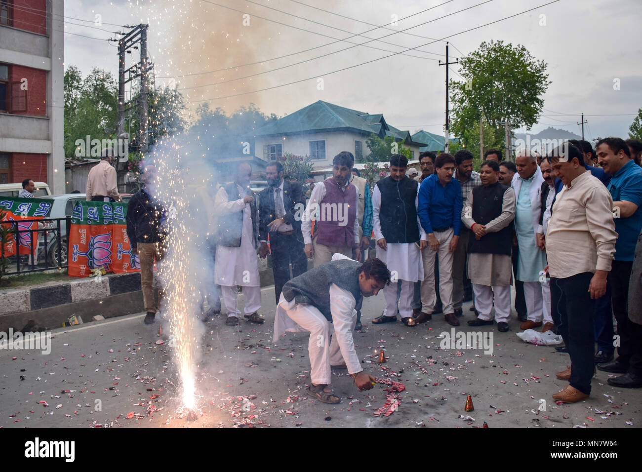 BJP lavoratori visto guardando il firecrakers come si celebra il partito votare portano a Srinagar il martedì. Il Bharatiya Janata Party (BJP), Kashmir, unità di oggi scoppiare petardi e dolciumi distribuiti al di fuori del suo partito ufficio qui a celebrare la derivazione elettorale in voti in Karnataka elezioni. Foto Stock