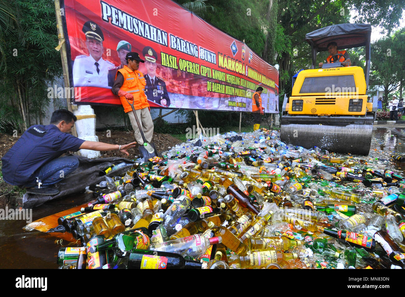 Bogor, Indonesia. 14 Maggio, 2018. Distruzione del delitto di migliaia di bottiglie di alcol e droga i risultati dell'operazione di polizia città di Bogor. Prove distrutte, 12,489 bottiglie di alcol da varie marche, 47.55 grammi di marijuana, 9 grammi di shabu narcotici, 10 grammi di stupefacenti sintetici, 1.127 droghe pesanti (elenco G), 500 litri di alcool e 15 Tipo di alcole di vino. Credito: Andi Muh Ridwan/Pacific Press/Alamy Live News Foto Stock