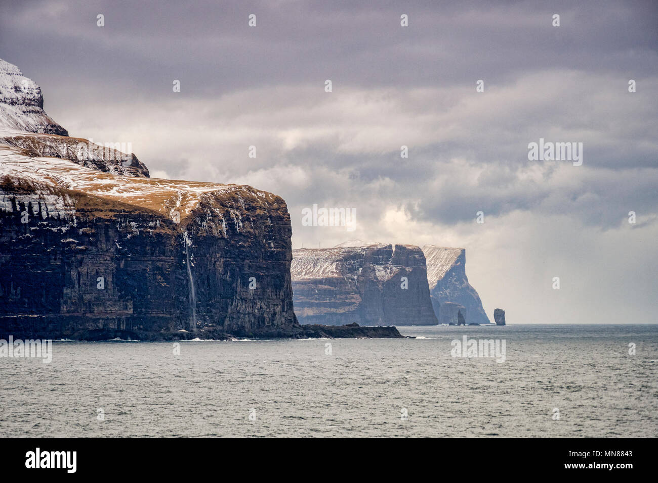 Scogliere, promontori e il mare di pile Risin og Kellingin sulla costa nord di Eysturoy, la seconda più grande delle isole Faerøer nel Nord Atlantico. Foto Stock