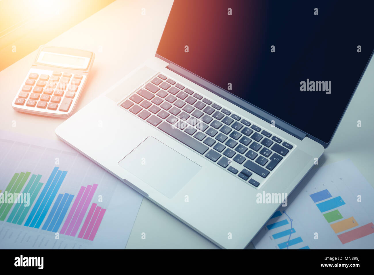 Grafici, diagrammi e calcolatrice sulla tabella di business. luogo di lavoro della gente di affari con la luce del sole . Foto Stock