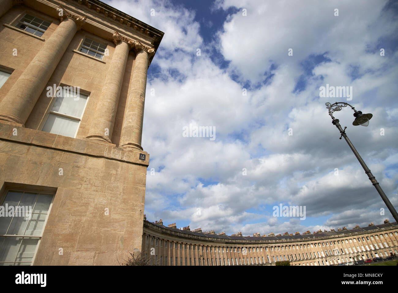 Vista del Royal Crescent strada residenziale case in stile georgiano bagno dall'end house ivi comprese le colonne e dettagli architettonici lampione England Regno Unito Foto Stock