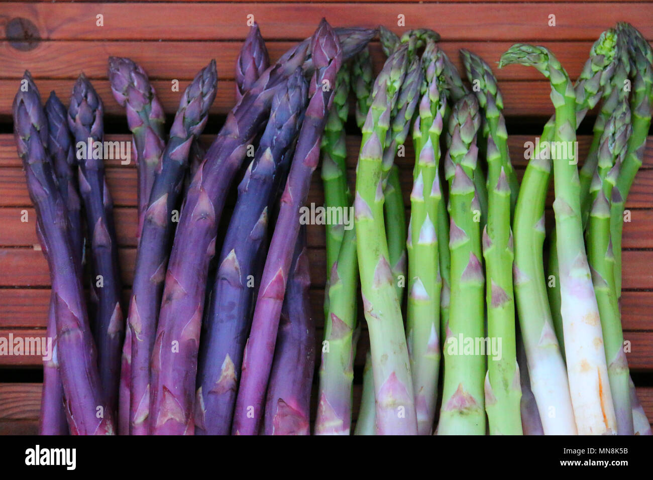 Verde e viola gli asparagi. Molto sano vegetale ungherese dal grande mercato. Foto Stock
