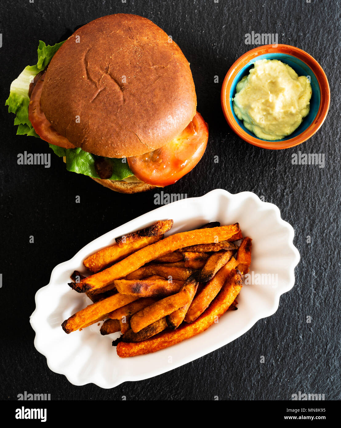 Vista superiore della hamburger succosa e croccante di patata dolce patate fritte e dip sul vassoio di ardesia Foto Stock