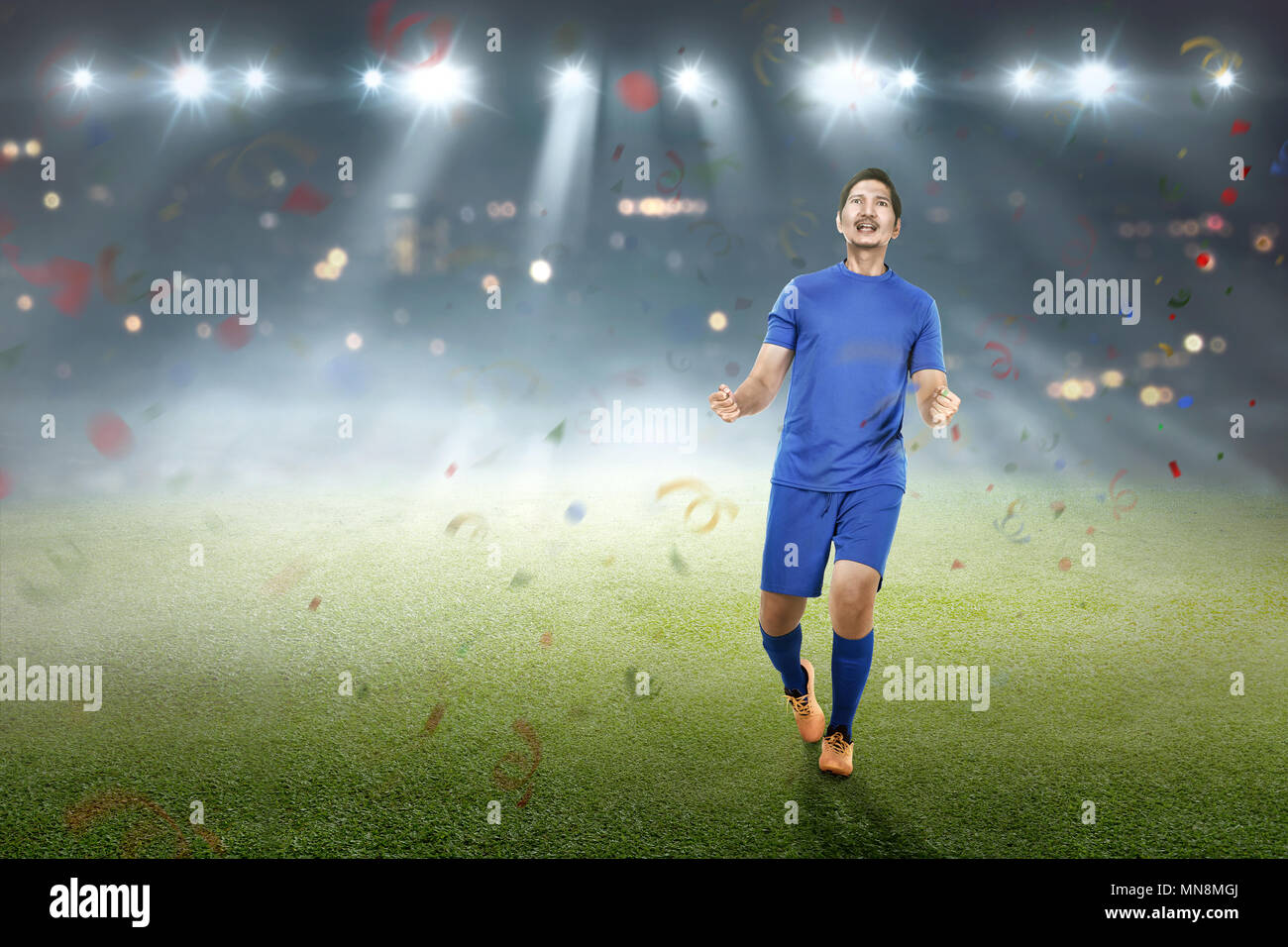 Celebrazione asian giocatore di calcio dopo un goal sul campo Foto Stock