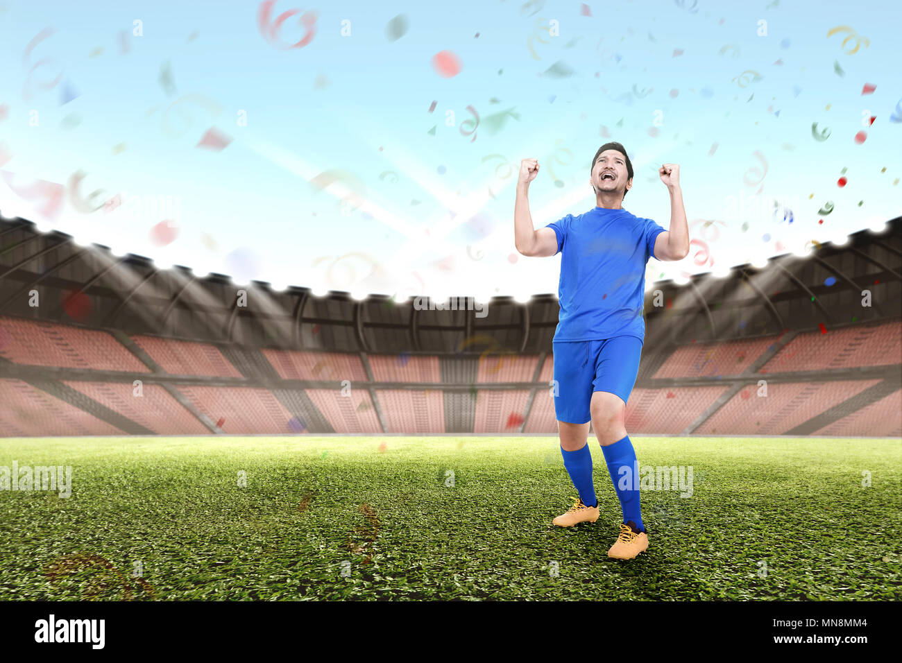 Attraente maschio asiatici giocatore di football celebra la vittoria in stadium Foto Stock