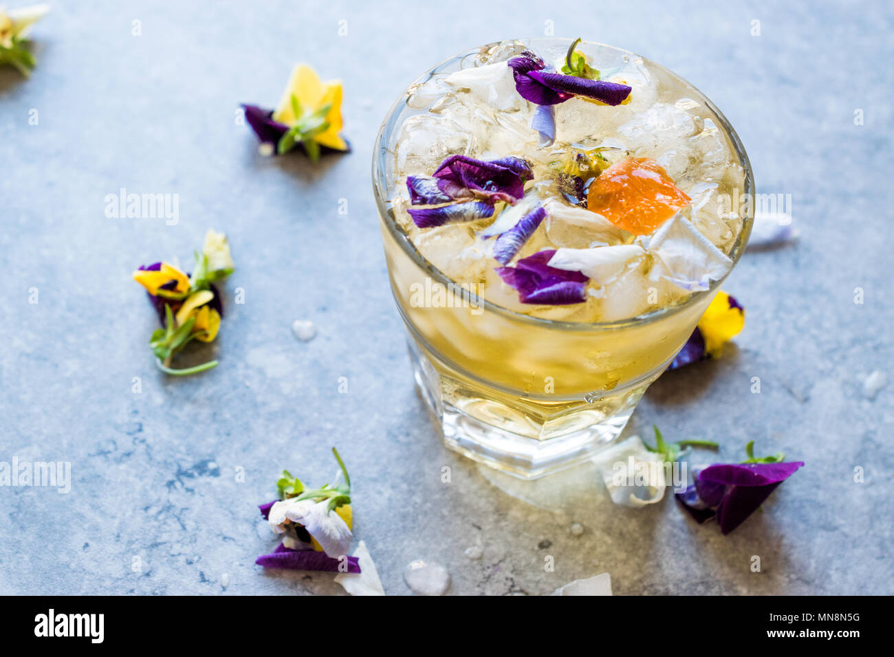 A base di erbe tè ghiacciato cocktail con fiori commestibili e ghiaccio  tritato. Bevanda organica Foto stock - Alamy