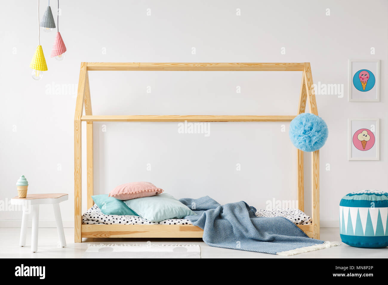 Pouf modellato accanto a un di legno artigianale di letto in camera per  ragazzi interno con poster colorati Foto stock - Alamy