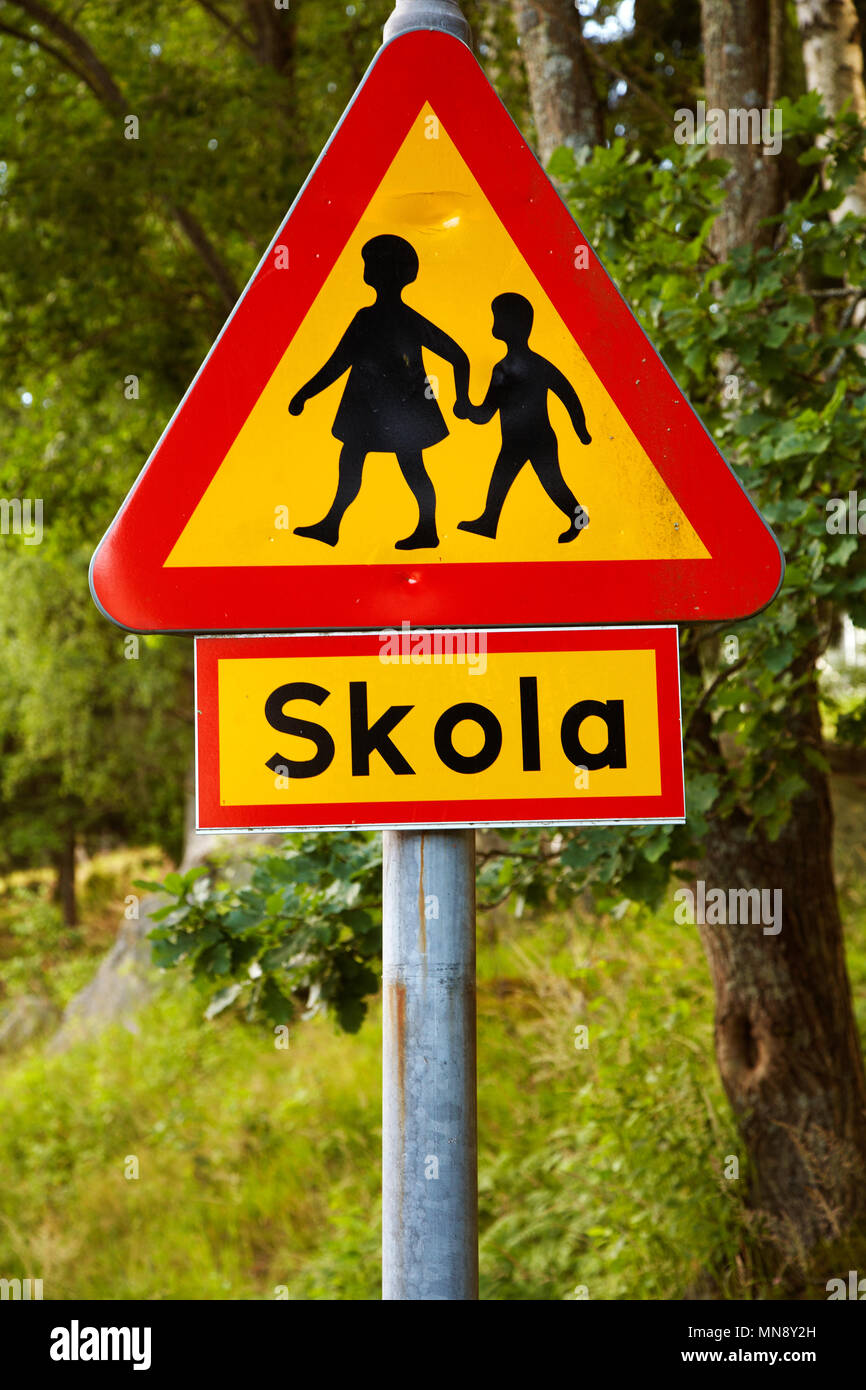 Svedese di cartello stradale attenzione dei bambini con il segno, che chiarisce che vi è una scuola nelle vicinanze. Foto Stock