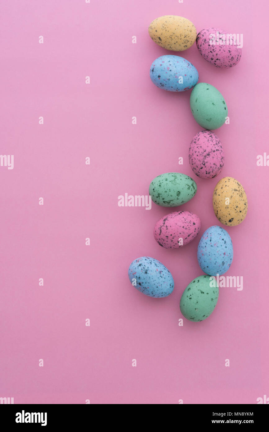 Mini punteggiate di uova di pasqua da sopra su sfondi colorati, con copyspace. Foto Stock