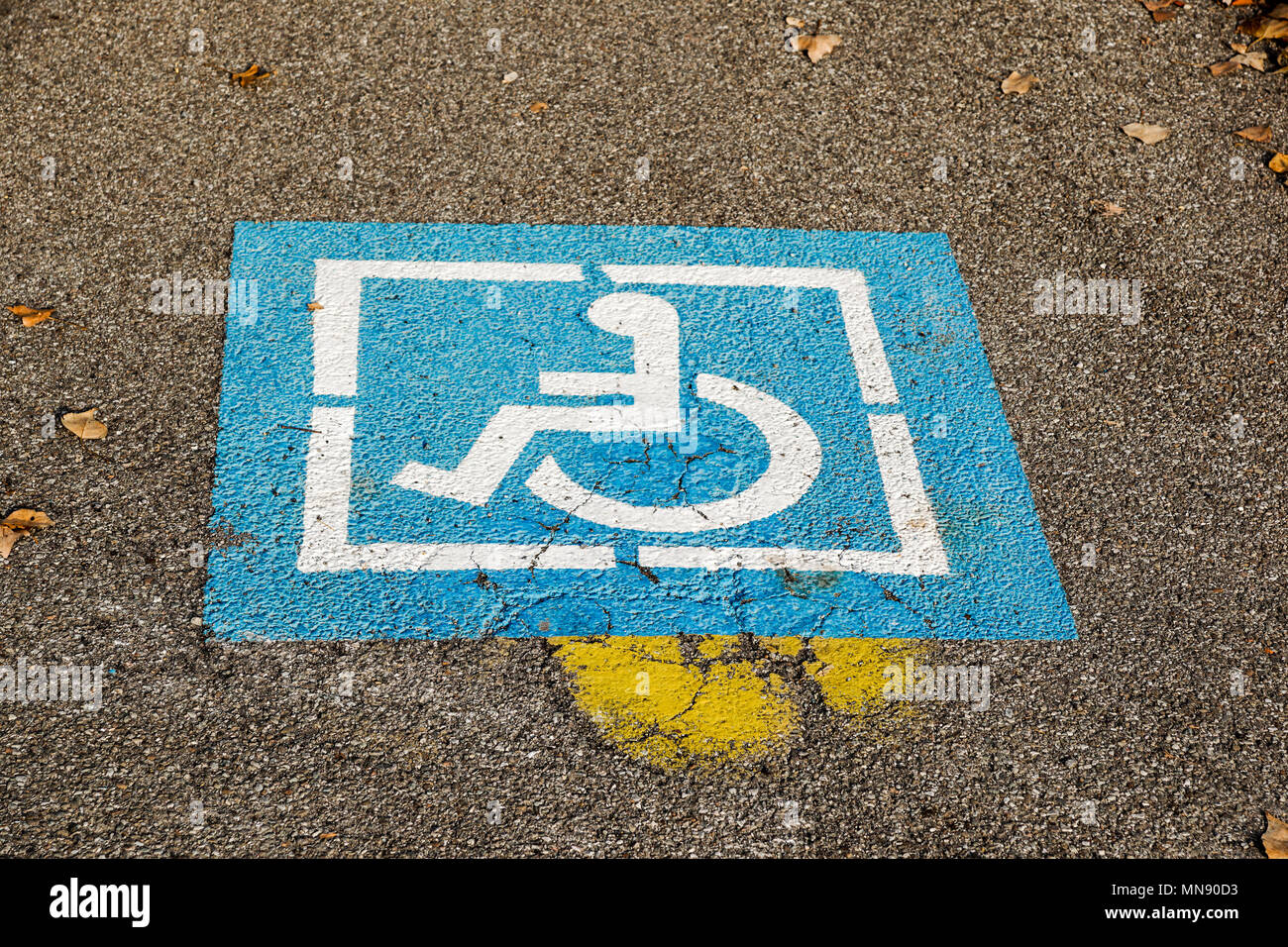 Portatori di handicap blu segno marchio posto parcheggio, parcheggio disabili permettere sign in pole con negozio di gas area stazione di sfondo, spazio di copia Foto Stock