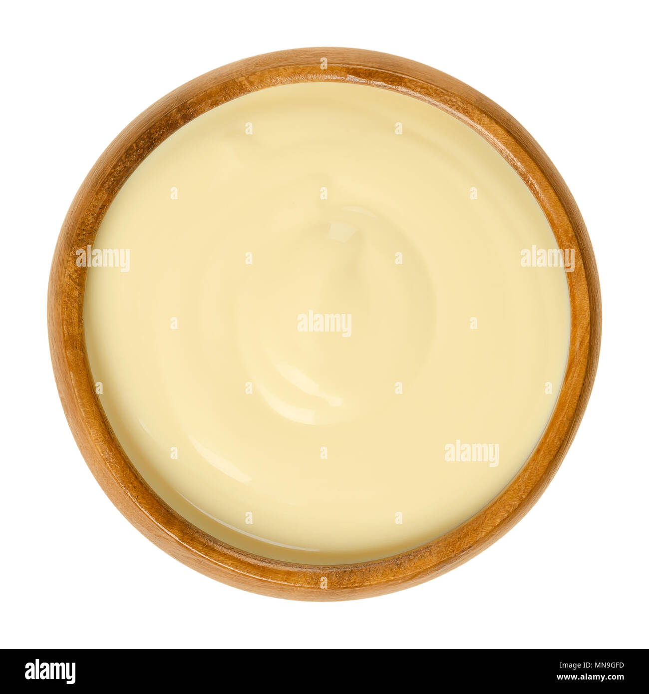 Salsa Hollandaise nella ciotola di legno. Anche la Salsa Olandese. Emulsione di tuorlo d'uovo, il burro, acqua e succo di limone. Mangiato con verdure al vapore. Foto Stock