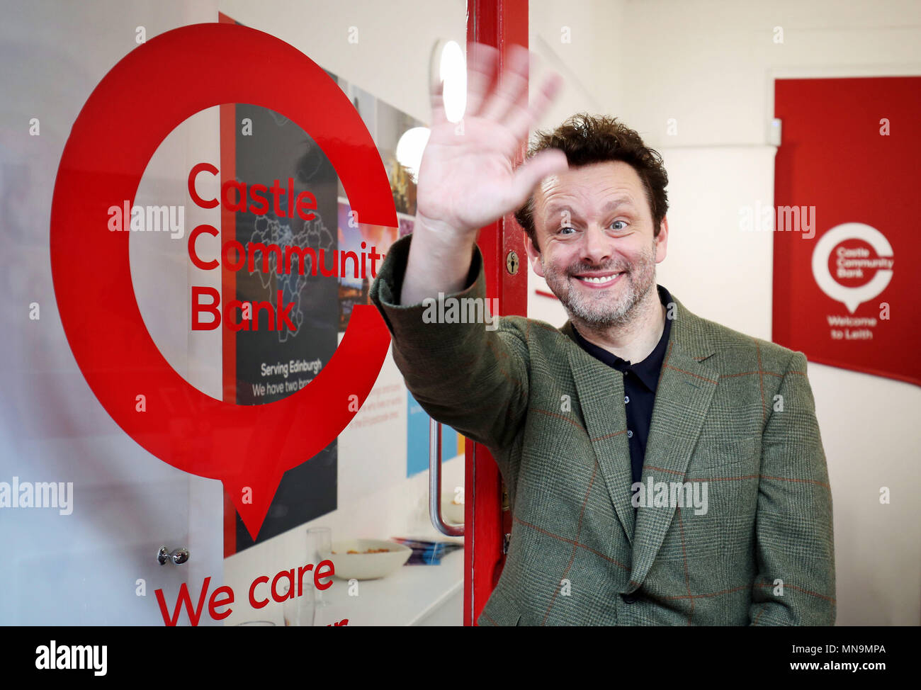 Attore e attivista sociale Michael Sheen in apertura del nuovo castello Banca Comunitaria sulla grande strada di giunzione in Leith, Edimburgo. Foto Stock