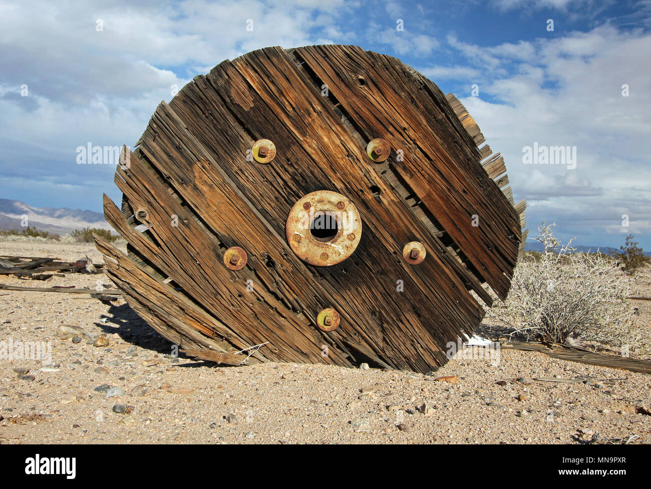 Un scheggiato in frantumi il vecchio e stagionato in legno tamburo del cavo si trova all'aperto nel deserto, High Desert, il Mojave, California la Valle delle Meraviglie, STATI UNITI D'AMERICA. Foto Stock