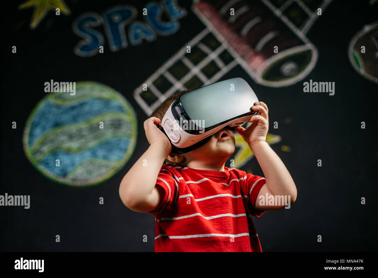 Un ritratto di un bambino che gioca con una realtà virtuale auricolare. Un giovane ragazzo che indossa e di apprendimento con un VR bicchieri. Foto Stock