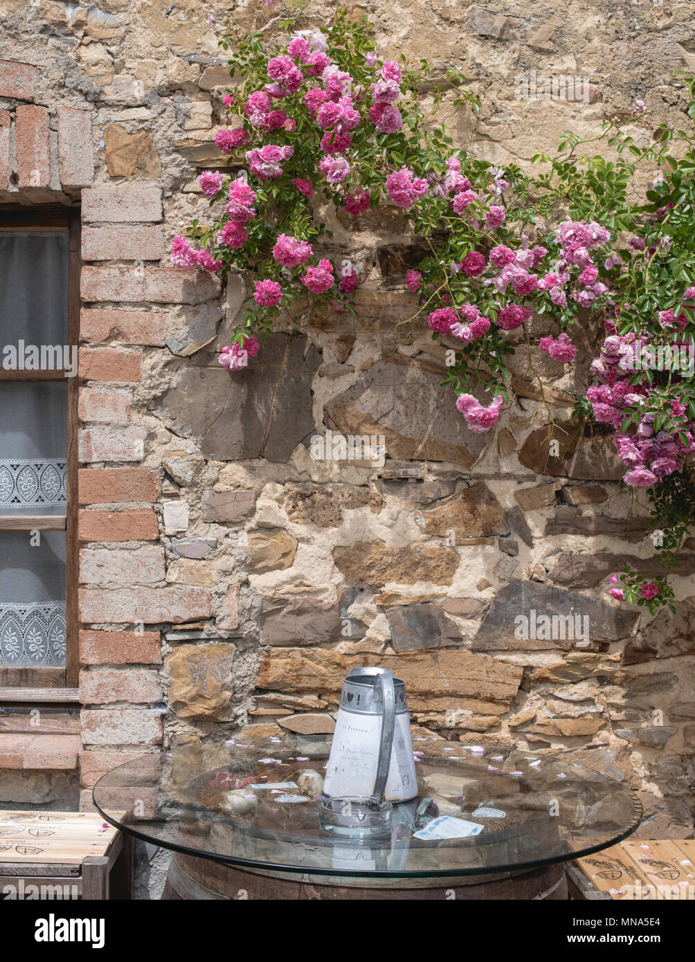 Un'annaffiatura può poggiare su un tavolo all'esterno di una fattoria al ristorante a tavola nella Toscana rurale, Italia. Foto Stock