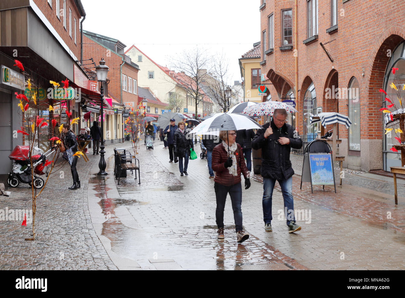 Ystad, Svezia - 15 Aprile 2017: La Pasqua decorate shopping street Ostra Storgatan durante la pioggia. Foto Stock