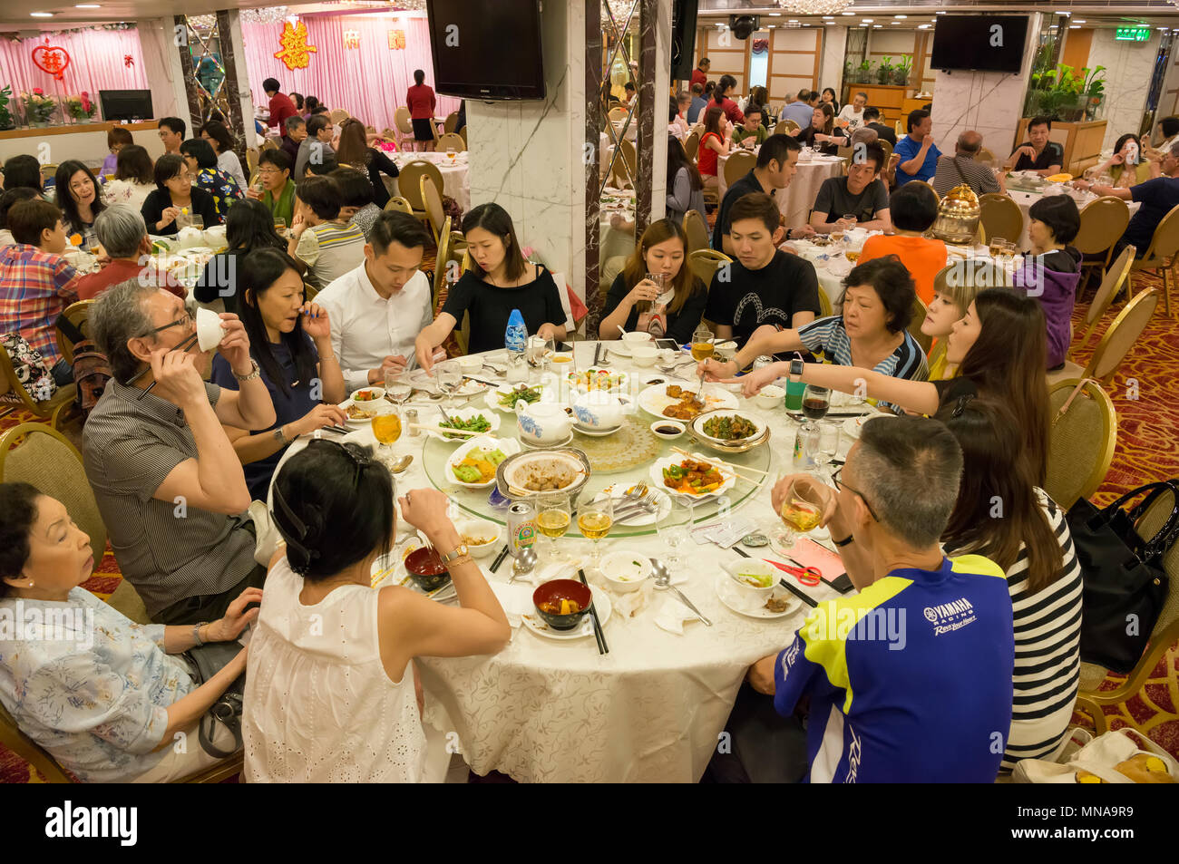 Famiglia cinese avente un pasto in un ristorante Cinese di Hong Kong , Cina. Foto Stock