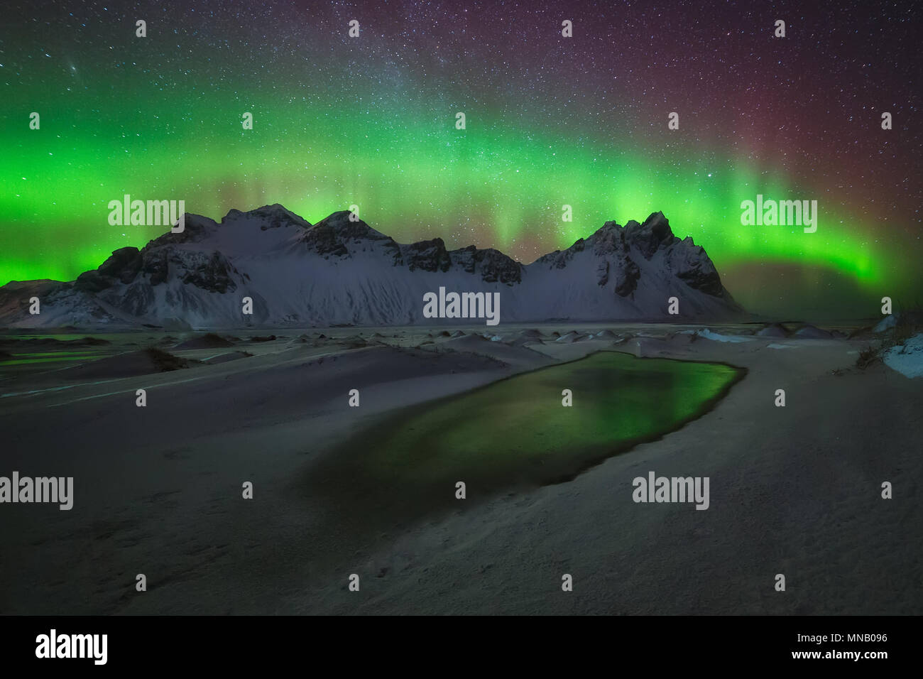 Aurora Boreale verde riflessione sull'acqua a Stokksnes Foto Stock
