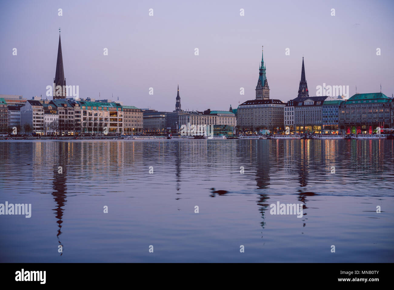 Il fiume Alster e dal municipio di Amburgo - Rathaus a molla nel crepuscolo serale Foto Stock