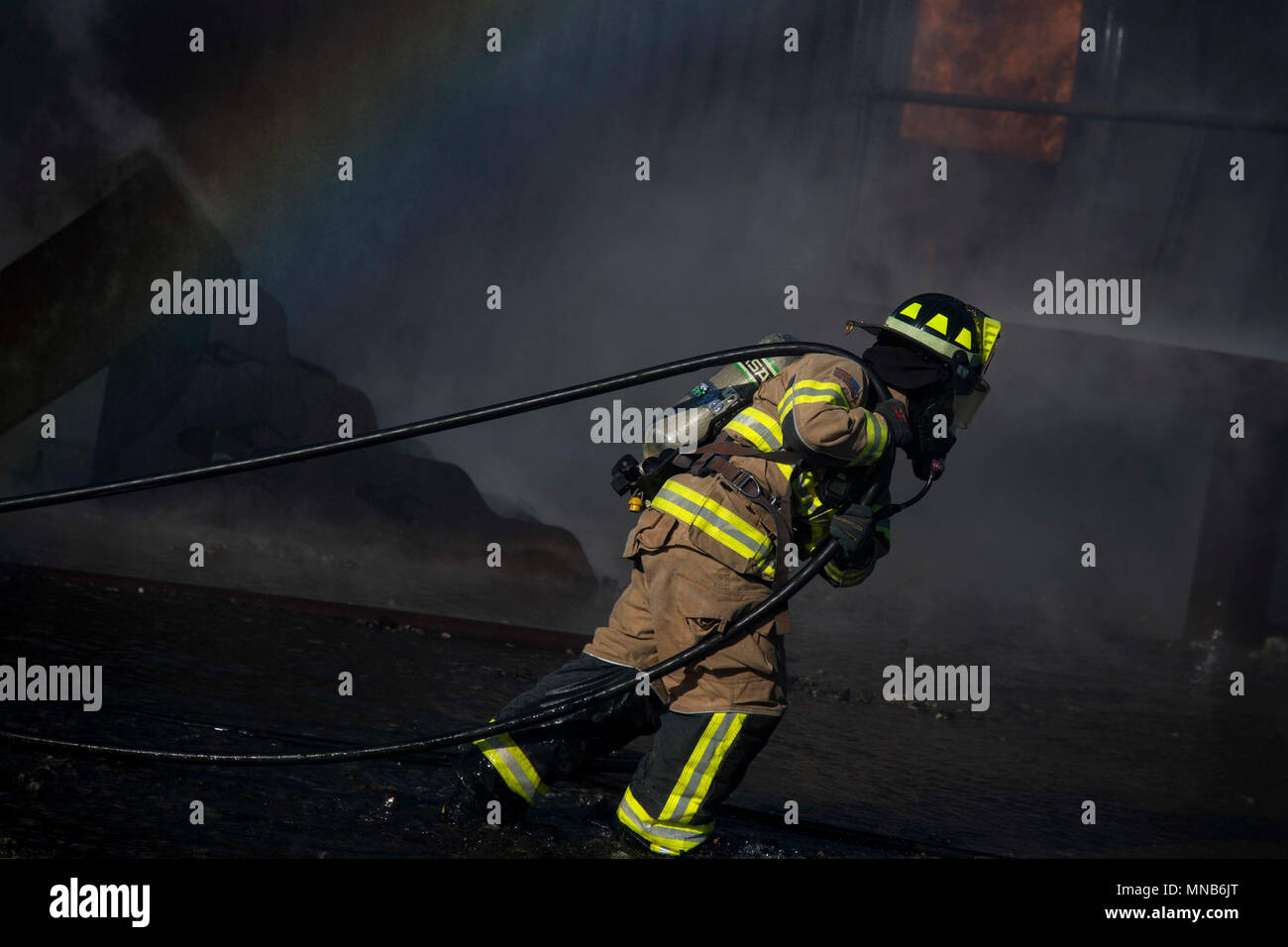 Un vigile del fuoco dal 23d' ingegnere civile Squadron (CES) porta un tubo antincendio durante un live-fuoco bruci esercizio, Marzo 15, 2018 a Moody Air Force Base, Ga. I vigili del fuoco dalla 23d CES condotta l'esercizio per dimostrare il velivolo di soccorso le capacità di estinzione per i leader della comunità e Moody's comandanti onorario. (U.S. Air Force Foto Stock