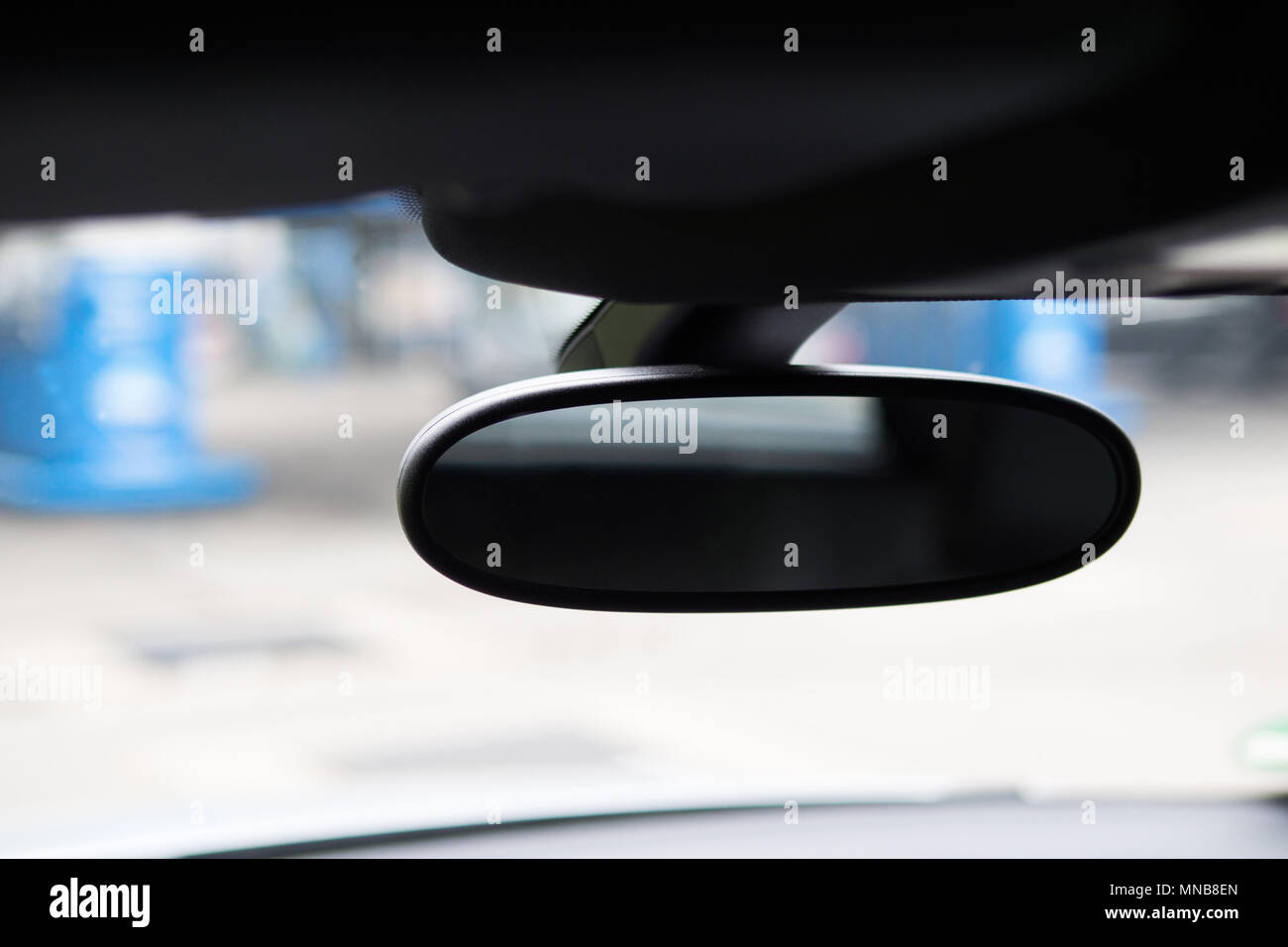 Specchio auto visto dall'interno di un automobile e uno sfondo sfocato. Messa a fuoco selettiva. Close up. Foto Stock