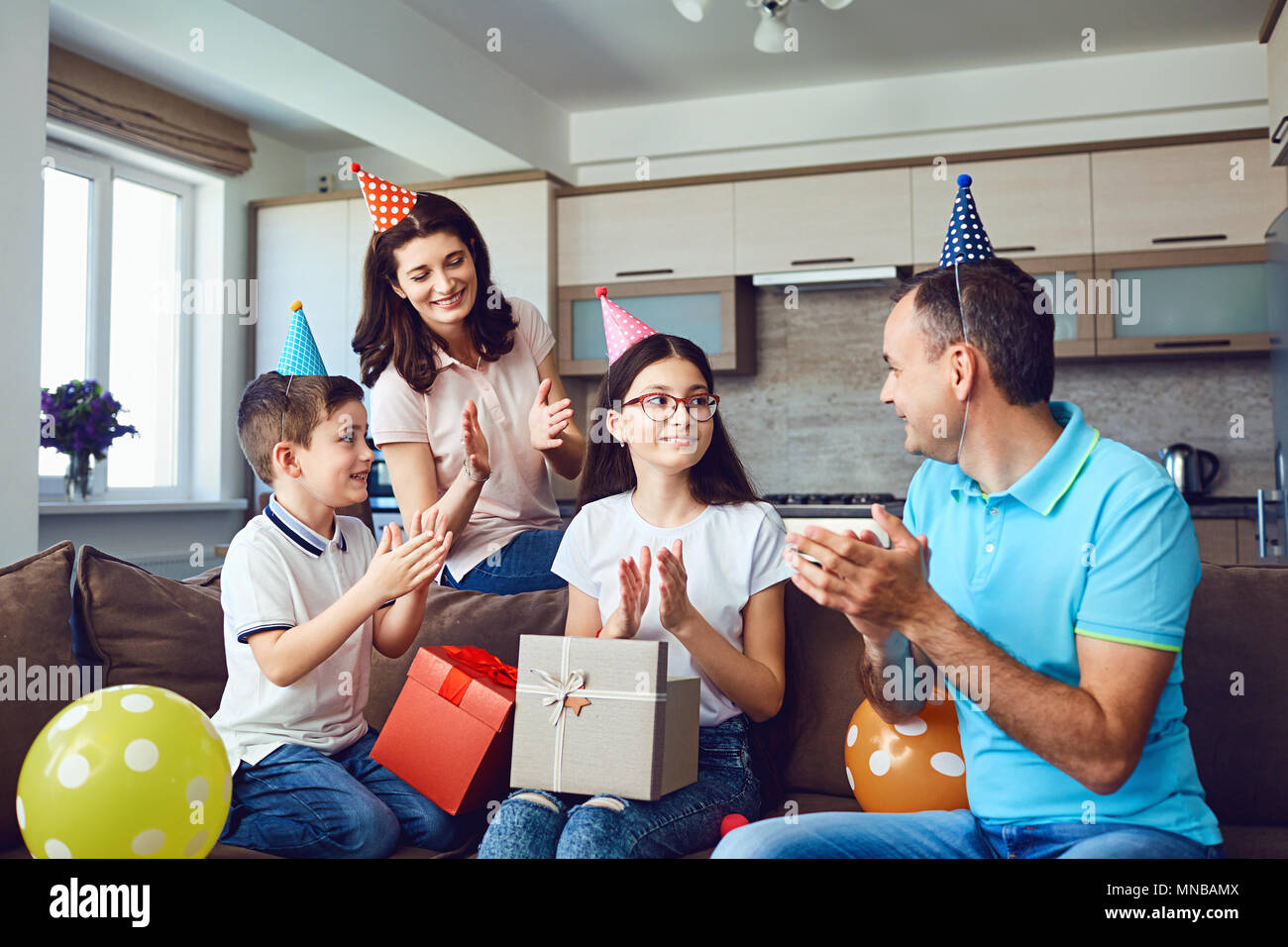 La famiglia felice con la torta su festa di compleanno Foto Stock