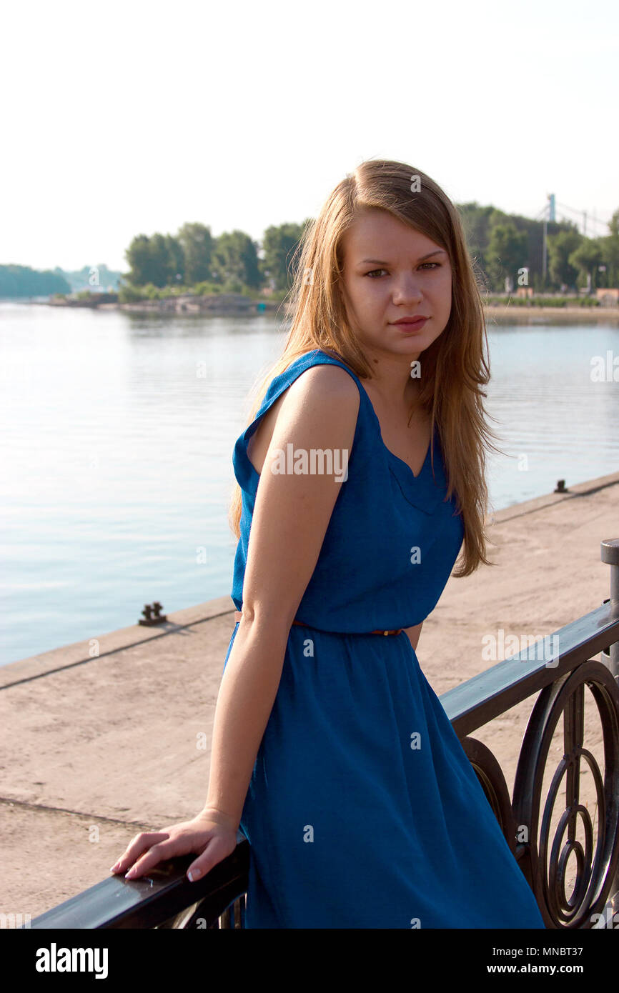 Ragazza in un abito blu sullo sfondo del fiume. L'Ucraina. Kiev. Obolon Foto Stock