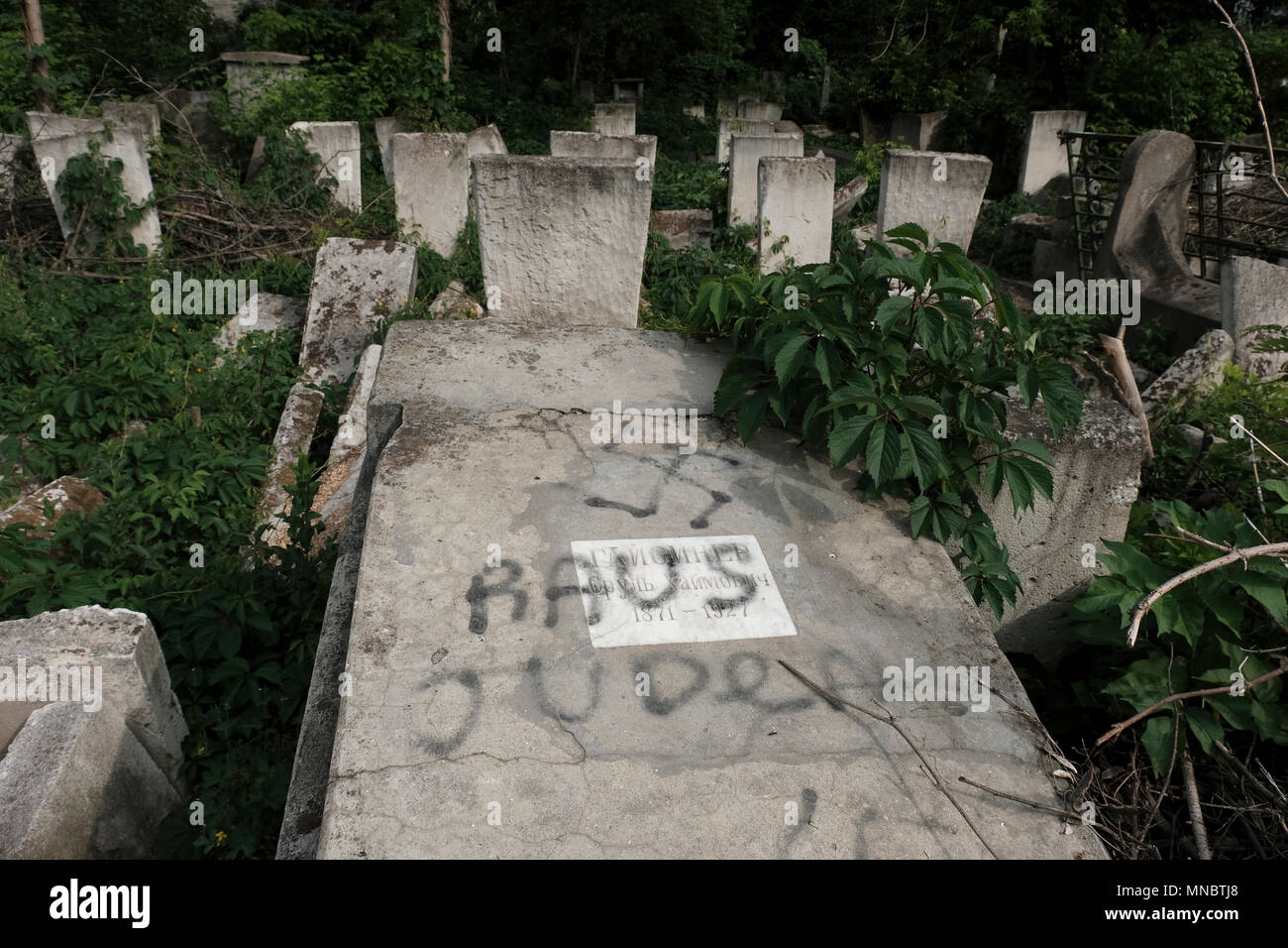 Una tomba desecrata con la svastika nazista e una frase in tedesco 'Raus Juden' presso il cimitero ebraico uno dei più grandi cimiteri ebrei in Europa nella città di Chisinau anche noto come Kishinev, la capitale della Repubblica di Moldova Foto Stock
