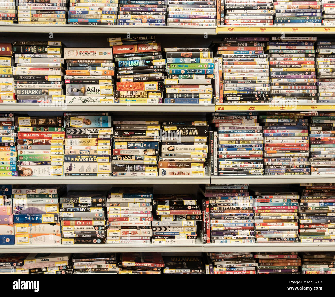 DVD e video impilati su piani di appoggio in convertitori di cassa pawnbrokers. Regno Unito Foto Stock