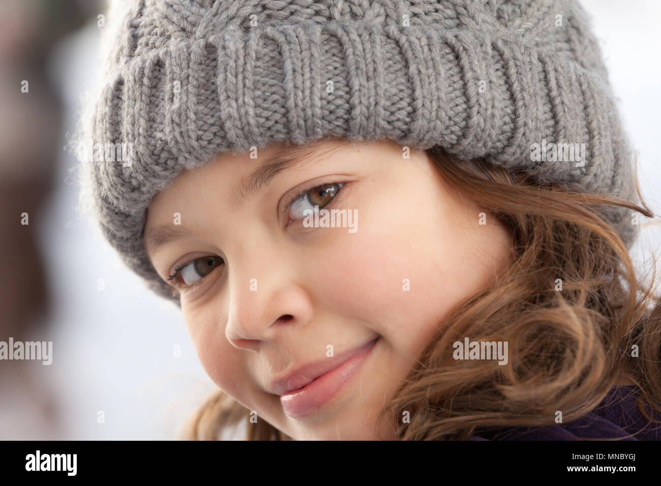 Primo piano di una informale bambina con cappello di lana, all'aperto Foto Stock