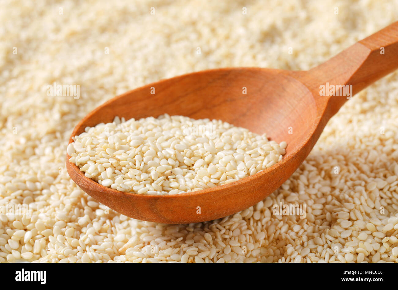 Cucchiaio di sano di semi di sesamo su semi di sesamo background - dettaglio Foto Stock