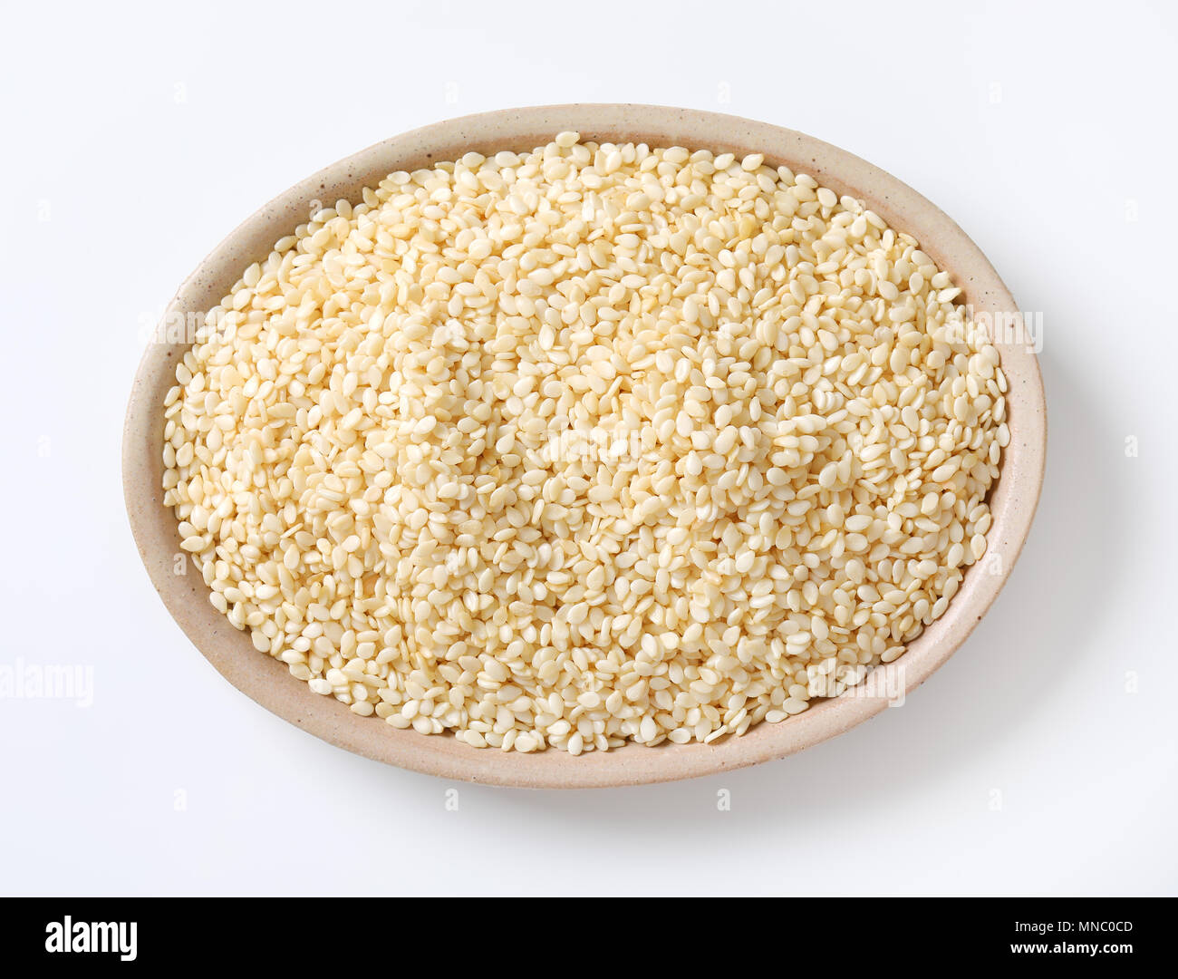 Ciotola di sano di semi di sesamo su sfondo bianco Foto Stock
