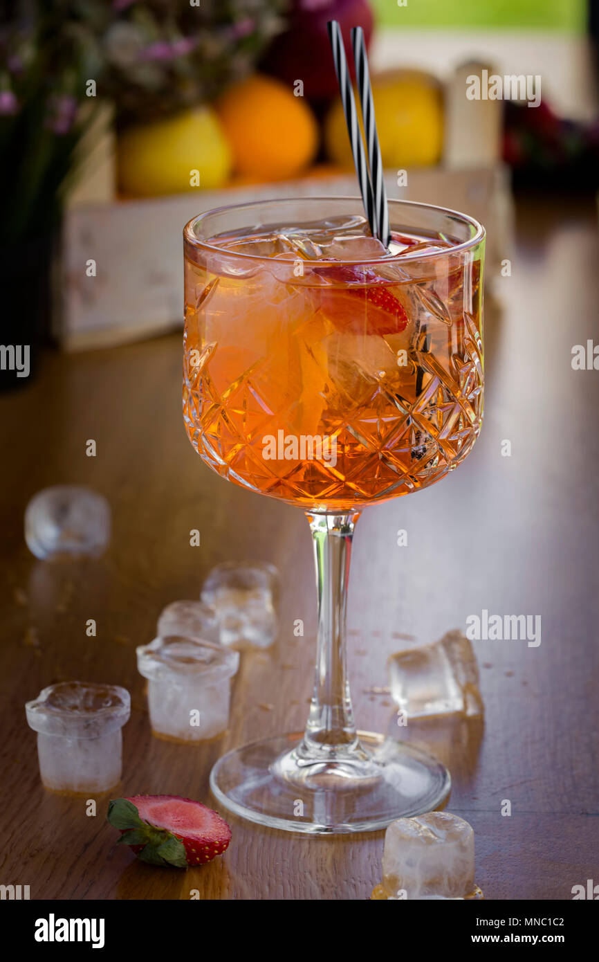 Cocktail con vodka, fragole e limone in vetro sulla barra con cubetti di ghiaccio Foto Stock