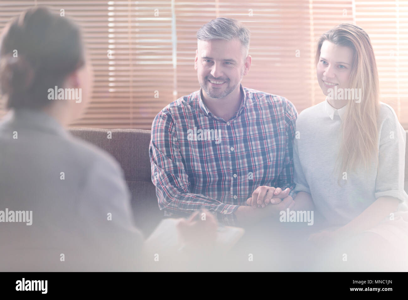 Flare di sorridere e bella coppia sposata durante la consultazione con un mediatore Foto Stock