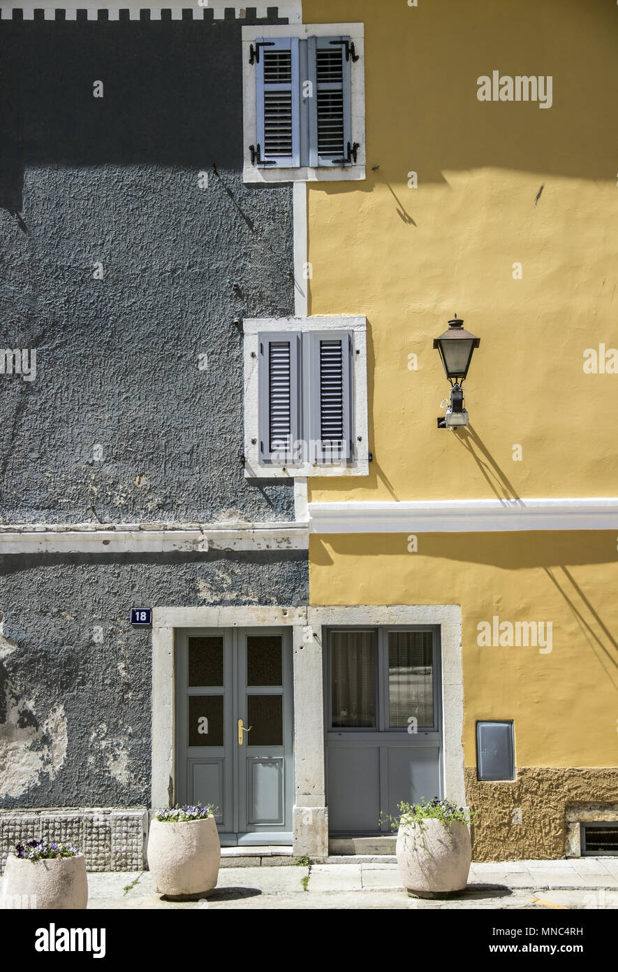 Orsera, Istria, Croazia, Aprile 2018 - Bicolor parete anteriore di un vecchio edificio residenziale con due ingressi Foto Stock