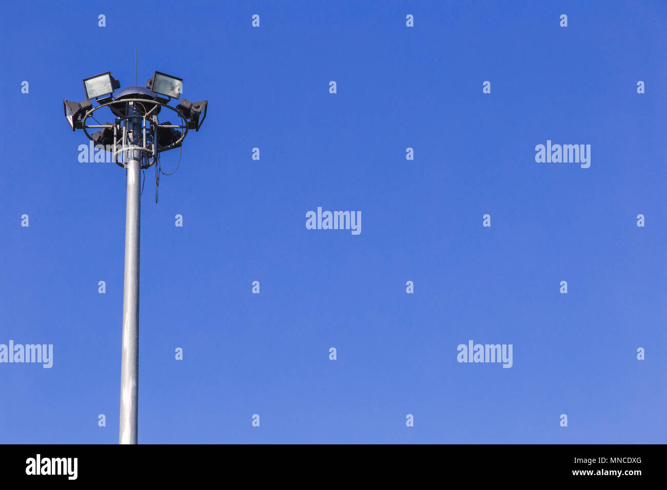 Faretti torre alta tensione in stadio sportivo sul cielo blu sullo sfondo. Foto Stock