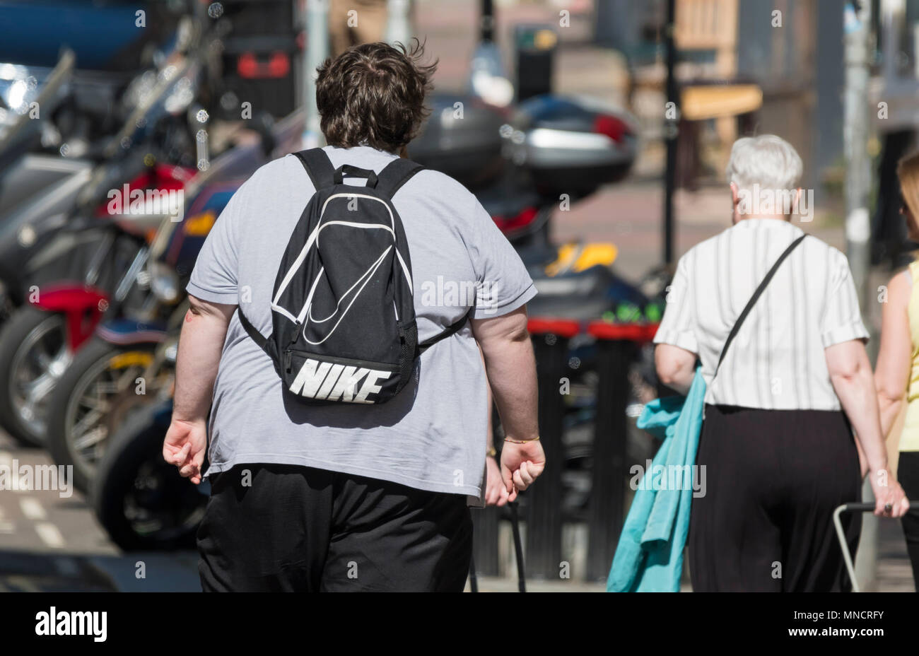 Uomo obesi da dietro a piedi nel Regno Unito. Concetto di sovrappeso. Foto Stock