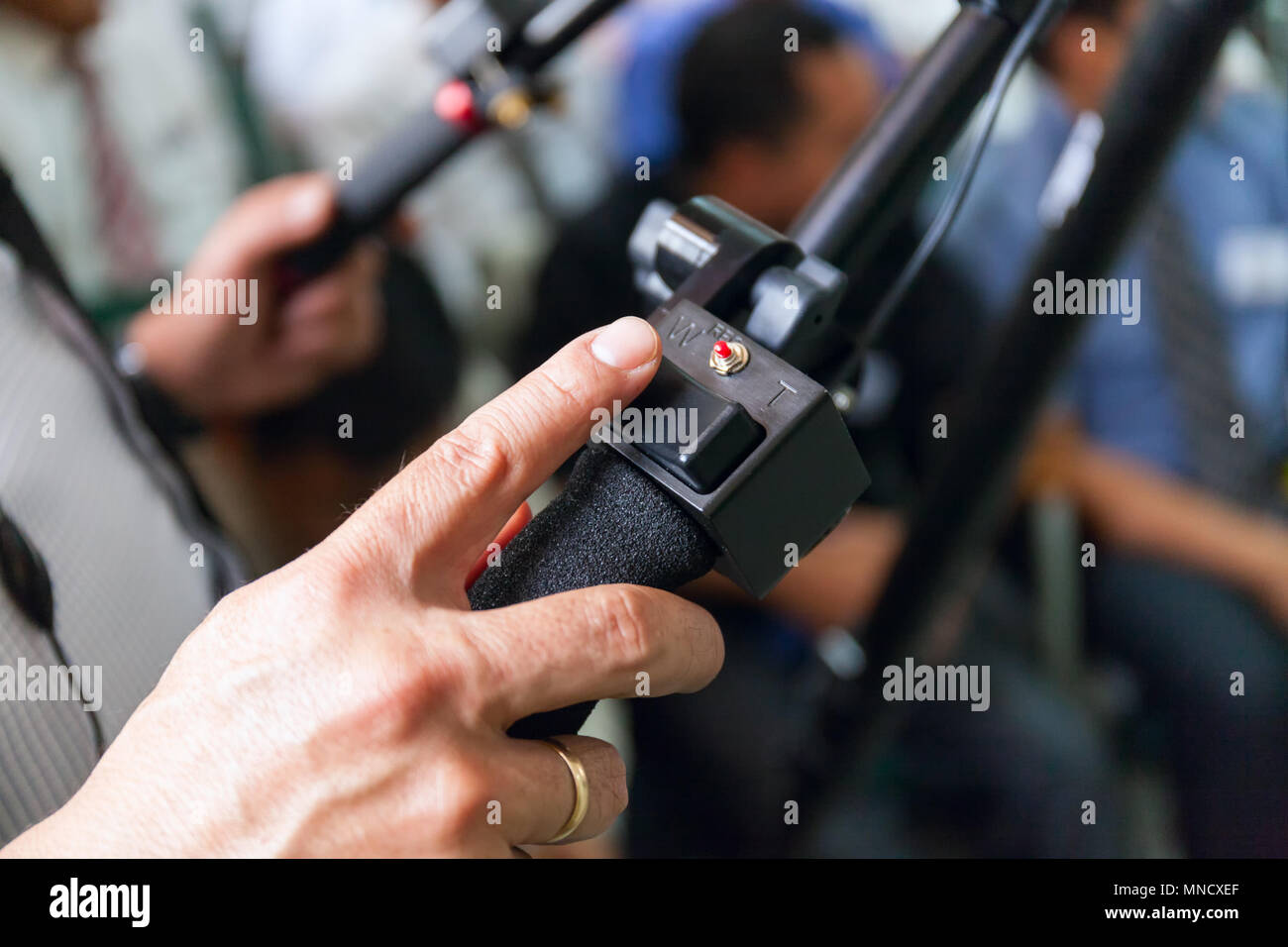 Close-up della fotocamera di lavoro di man mano, l'operatore al lavoro. nella sala piena di gente Foto Stock