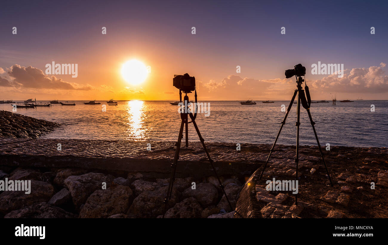 Silhouette della fotocamera su treppiede mare riprese con il tramonto del sole. Foto Stock