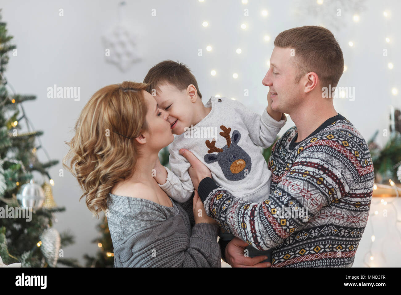 Il padre e la madre con il figlio a casa durante il periodo di Natale Foto Stock