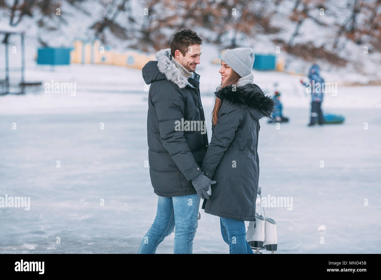 Felice coppia permanente sulla pista di pattinaggio su ghiaccio Foto Stock