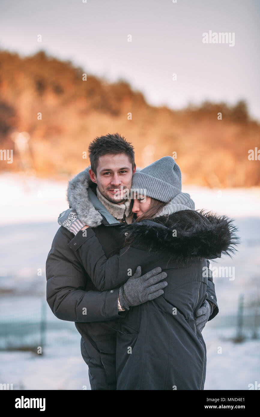 Ritratto di uomo sorridente abbracciando la donna durante il periodo invernale Foto Stock