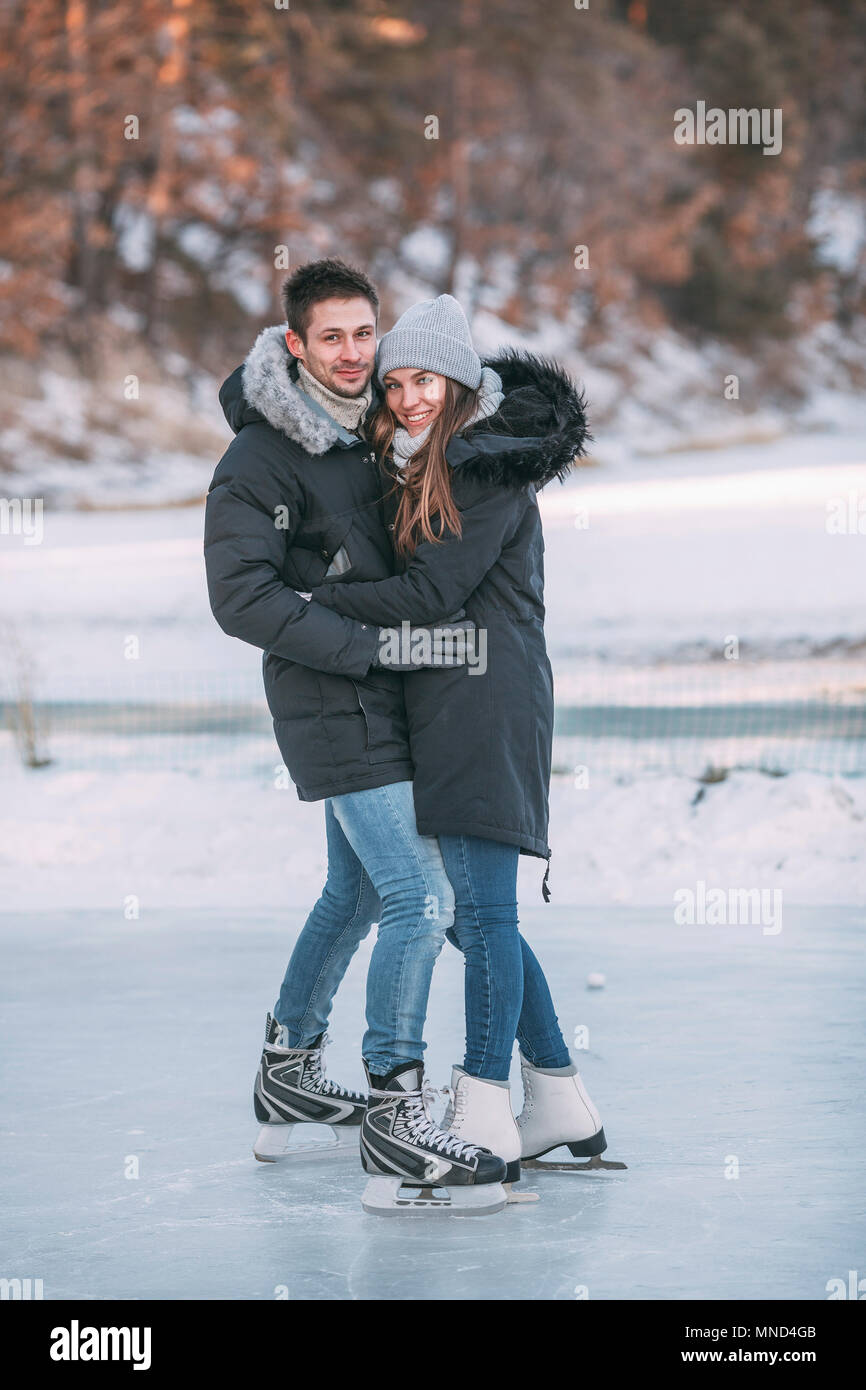 A piena lunghezza ritratto della coppia felice abbracciando mentre godendo di pattinaggio sul ghiaccio Foto Stock