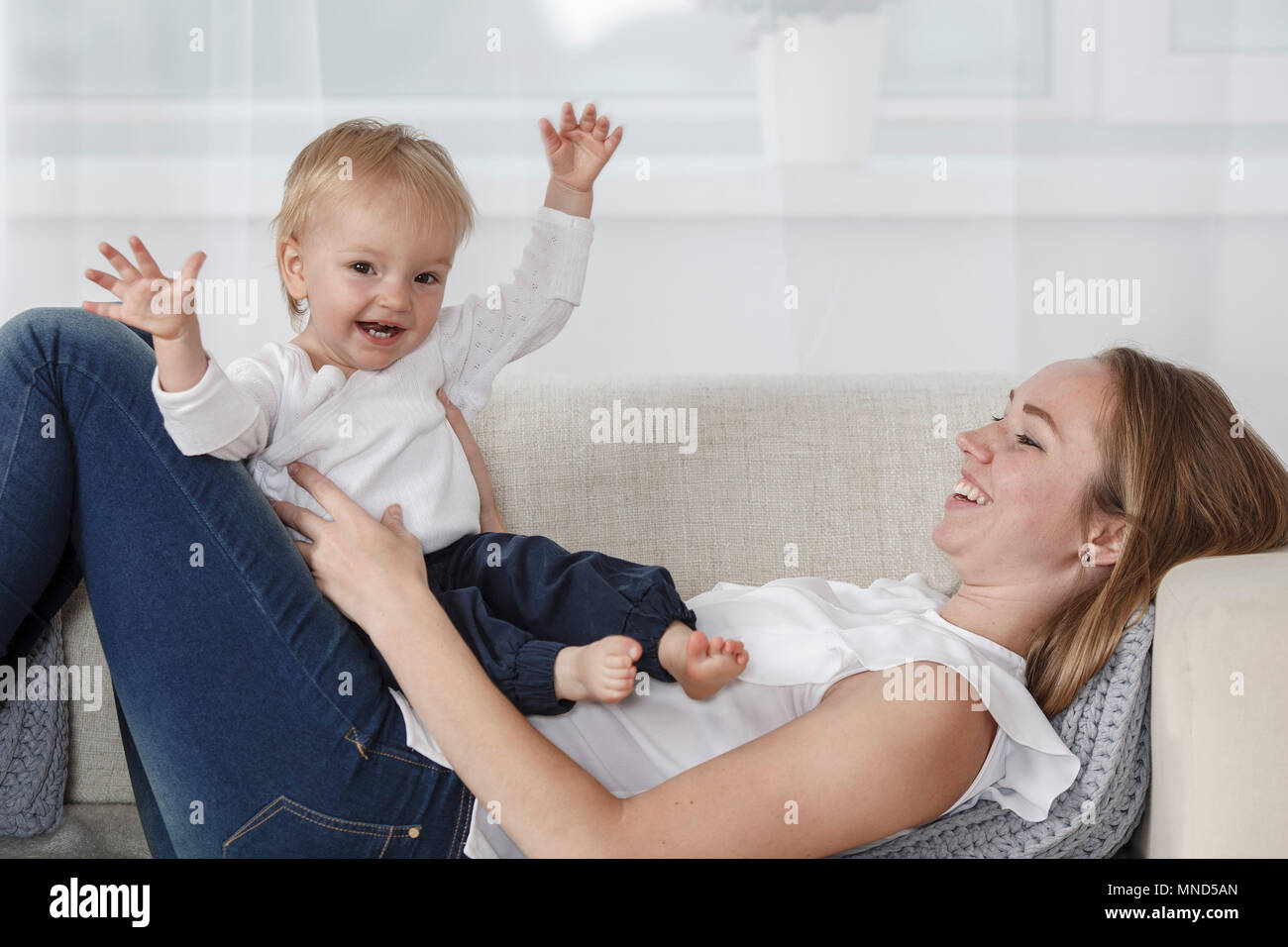 Felice madre e figlia godendo sul divano di casa Foto Stock