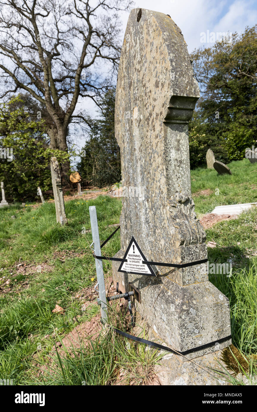 Pietra tombale tenuto fino al post e le fascette con l avvertenza che il memorial è pericoloso, Stoke on Trent, Regno Unito Foto Stock