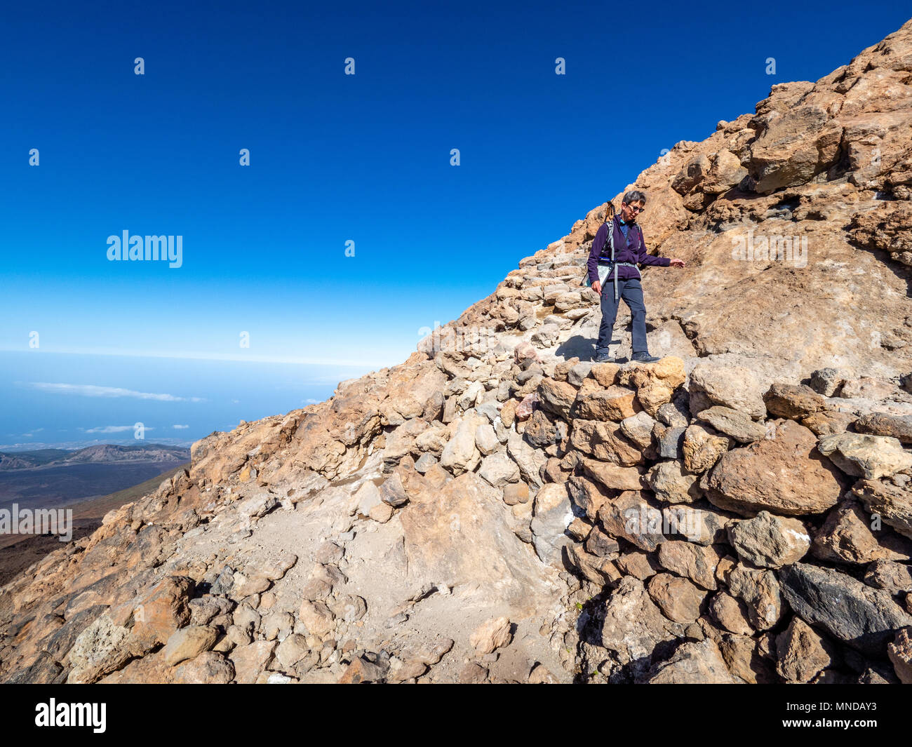 Il camminatore femmina discendente dalla fumante cratere sommitale del vulcano attivo del monte Teide a 3718 metri su Tenerife la più grande delle isole Canarie Foto Stock