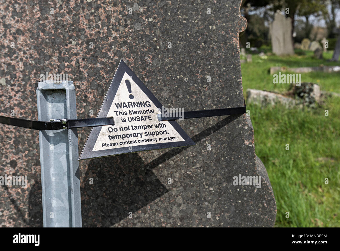 Pietra tombale tenuto fino al post e le fascette con l avvertenza che il memorial è pericoloso, Stoke on Trent, Regno Unito Foto Stock