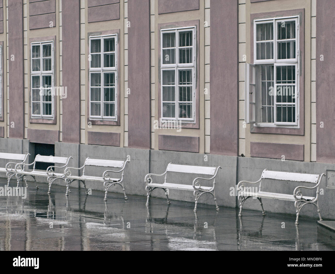 Una fila di dipinto di bianco di posti a sedere di fronte a finestre alte in Praga. Foto Stock